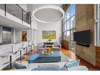 Spacious living room featuring concrete wall, modern decor, and floor-to-ceiling windows with city views at 1050 Cherokee St # 403, Denver, CO 80204