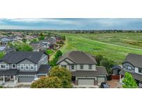 Lovely two-story home overlooking expansive community green space and many neighborhood homes nearby at 16747 E 97Th Pl, Commerce City, CO 80022