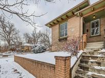 Brick home with snow covered yard and steps leading to the front entrance at 3256 N Clay St, Denver, CO 80211