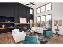 Bright living room boasts a fireplace, high ceilings, and large windows for ample natural light at 9983 Cottoncreek Dr, Highlands Ranch, CO 80130