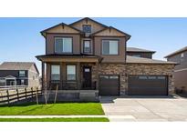 Charming two-story home with a well-manicured lawn, a two car garage and stone detailing at 1876 Chaffee Crest Dr, Berthoud, CO 80513