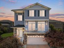 Charming two-story home featuring a welcoming front porch and a well-maintained yard at sunset at 239 S Old Hammer St, Aurora, CO 80018