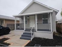 Charming single-Gathering home featuring covered porch, gray paint, and manicured landscaping at 4673 Sherman St, Denver, CO 80216
