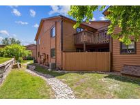 Inviting townhouse exterior with a private deck and meticulously landscaped yard with a stone pathway at 9427 W 89Th Cir, Broomfield, CO 80021