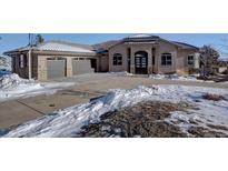 Two-story house with attached three-car garage, snow covered landscaping, and a basketball hoop at 6959 Surrey Trl, Littleton, CO 80125