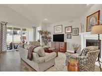 Inviting living room featuring hardwood floors, large windows, fireplace, and comfortable seating at 1982 Peralta Loop, Castle Rock, CO 80104
