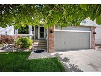 Charming two-story home with attached garage and inviting front yard, shaded by a large tree at 5750 S Youngfield St, Littleton, CO 80127