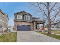 Charming two-story home with a stone facade, a two-car garage, and a covered front porch at 1192 S Fultondale Cir, Aurora, CO 80018