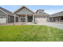 Charming home with a well-manicured lawn, a covered porch and an attached two car garage at 331 Josef Cir, Fort Lupton, CO 80621