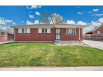 Charming brick home featuring a well-maintained lawn and classic design elements under a bright sky at 5510 Troy St, Denver, CO 80239