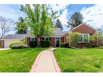 Charming brick home featuring a well-manicured lawn, mature trees, and a welcoming walkway to the front door at 3756 S Forest Way, Denver, CO 80237