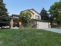 Charming two-story home with a manicured lawn and a two car garage at 9810 Venneford Ranch Rd, Highlands Ranch, CO 80126