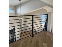 Open loft area featuring contemporary black metal railings and modern light fixture, offering a stylish and airy feel at 9810 Venneford Ranch Rd, Highlands Ranch, CO 80126