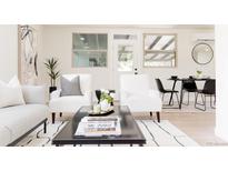 Open living room features modern seating, a coffee table with magazines, and a view of the backyard at 1390 S Jasmine Way, Denver, CO 80224