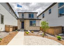 Charming two-story home featuring stone accents and a well-maintained, low maintenance front yard at 21242 E 63Rd Dr, Aurora, CO 80019