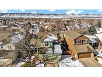 Scenic aerial view of a neighborhood with snow and mountain backdrop on a bright day at 9401 Wolfe St, Highlands Ranch, CO 80129
