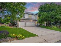 Charming two-story home with a well-manicured lawn, mature trees, and a spacious three-car garage at 6506 S Robb Way, Littleton, CO 80127