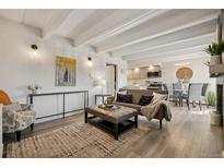 Bright living room with beamed ceilings flows into kitchen and dining room at 655 N Pearl St # 301, Denver, CO 80203