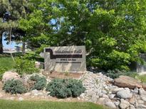 Community sign for Woodstream Falls with lush landscaping and stone accents at 9995 E Harvard Ave # 177, Denver, CO 80231