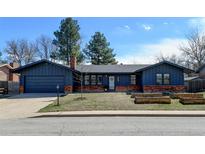 Charming blue single-story home with brick accents, a well-manicured lawn, and a cozy, inviting curb appeal at 7476 Park Lane Rd, Longmont, CO 80503