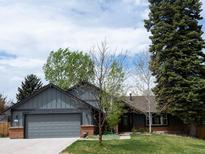 Charming gray home with brick accents, mature trees, and well-maintained front lawn creates great curb appeal at 5973 S Krameria St, Centennial, CO 80111
