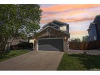 Charming two-story home with a stone-accented facade and well-maintained lawn at sunset at 19157 E Progress Ave, Centennial, CO 80015