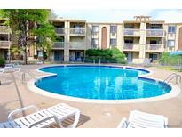 Resort-style pool featuring lounge chairs, a blue-tiled perimeter, and access to the apartments' balconies at 1300 S Parker Rd # 110, Denver, CO 80231