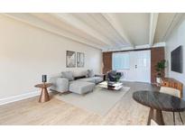 Bright living room features a modern sectional sofa, stylish decor, and ample natural light at 1180 Yosemite St # 110, Denver, CO 80220