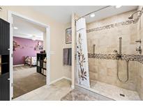 Bathroom with tiled shower and shower curtain, with view of the bedroom from doorway at 1128 S Duquesne Cir, Aurora, CO 80018