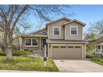 Inviting tan two-story home showcasing a two-car garage and well-manicured lawn at 6382 Freeport Dr, Highlands Ranch, CO 80130