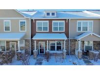 Attractive two-story townhome with stone accents and snowy front yard at 13616 Garfield St # B, Thornton, CO 80602