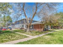 Charming townhome with blue siding, brick accents, and mature trees, nestled in a well-maintained lawn and landscaped community at 1287 S Wheeling Way, Aurora, CO 80012