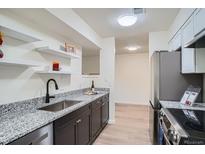 Modern kitchen featuring granite counters, stainless steel appliances, and sleek cabinetry at 1211 W 112Th Ave # B, Denver, CO 80234