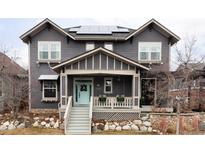 Charming home featuring a covered front porch, blue door, rock garden, and solar panels at 11745 Newton St, Westminster, CO 80031