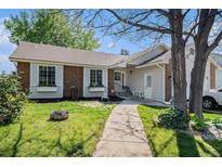 Charming home featuring a brick facade, well-maintained lawn, and inviting walkway leading to the front entrance at 1572 W Long Ave, Littleton, CO 80120