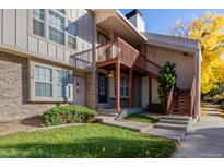 Charming townhome featuring a front yard, brick accents, and a cozy covered entry with stairs at 1128 S Ventura Cir # H, Aurora, CO 80017