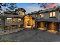 Stunning exterior showcasing a custom home with a stone facade, three-car garage, and a dramatic entrance at 2063 Montane E Dr, Golden, CO 80401