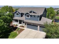 Stunning two-story home with a three-car garage, beautiful landscaping, and mountain views at 879 Quintana Ln, Erie, CO 80516