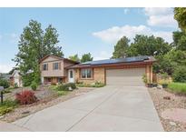 Charming home featuring a well-maintained lawn, solar panels, and a large driveway leading to a two-car garage at 2173 S Ouray St, Aurora, CO 80013