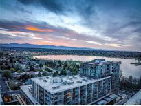 Stunning aerial view of community by lake, offering scenic mountain backdrop and colorful sunrise at 4200 W 17Th Ave # 411, Denver, CO 80204