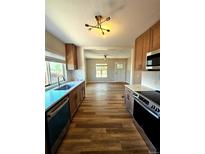 Modern kitchen boasts stainless steel appliances, light countertops, and wood-look flooring at 1435 N Uinta St, Denver, CO 80220