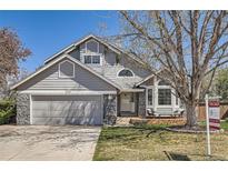 Charming home featuring a gray exterior, stone accents, a well-maintained yard, and a two-car garage at 1737 Jules Ct, Highlands Ranch, CO 80126