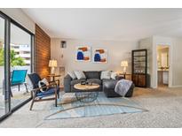 Inviting living room features a comfortable gray sectional, stylish decor, and access to a private balcony at 2880 S Locust St # 305N, Denver, CO 80222