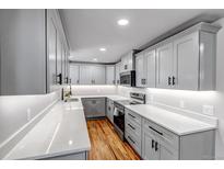 Modern kitchen with stainless steel appliances, gray cabinetry and quartz countertops at 10025 W 8Th Ave, Lakewood, CO 80215