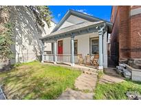 Charming home featuring a welcoming porch, vibrant red door, and well-maintained front lawn at 2322 Arapahoe St, Denver, CO 80205