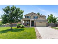 Charming two-story home with landscaped front yard, inviting entrance, and attached two-car garage at 201 Shenandoah Way, Brighton, CO 80603