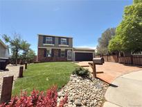 Charming two-story home with a well-manicured lawn and colorful landscaping at 17212 E Oberlin Pl, Aurora, CO 80013