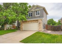 Charming two-story home boasts a two-car garage and stone accents enhancing its curb appeal at 5136 S Ceylon St, Centennial, CO 80015