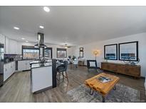 Open-concept living room and kitchen area with modern decor and stainless steel appliances at 8092 S Jay Dr, Littleton, CO 80128