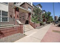 Brick building featuring an inviting entrance with staircase and well-maintained landscaping at 1727 Pearl St # 205, Denver, CO 80203